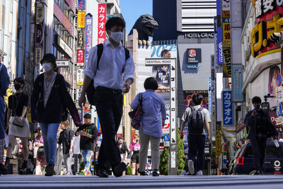 People wearing face masks to protect against COVID-19 walk past a crossing in Shinjuku, an entertainment district of Tokyo, Monday, Sept. 20, 2021. (AP Photo/Kiichiro Sato)