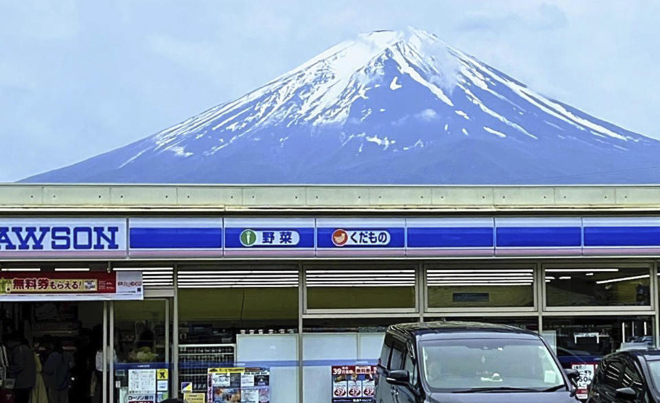 A photo shows an image of Mt. Fuji on a convenience store in Fujikawaguchiko Town, Yamanashi Prefecture on April 29, 2024. This spot has been crowded by foreign tourists because it looks like Mt. Fuji is standing on top of a convenience store Lawson. / Credit: Makoto Kimura / AP
