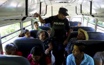 Un policía hace una inspección de rutina en un autobús en La Hachadura, localidad salvadoreña fronteriza con Guatemala, el 11 de diciembre del 2019, en el marco de políticas que tienen por fin reducir la emigración a EEUU. (AP Photo/Eduardo Verdugo)