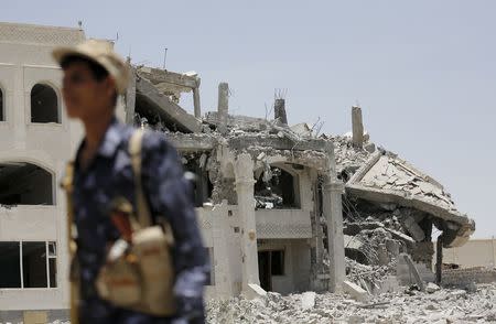 A Houthi militant walks at the yard of residence of the military commander of the Houthi militant group, Abdullah Yahya al Hakim, after it was hit by an airstrike, in Sanaa April 28, 2015. REUTERS/Khaled Abdullah