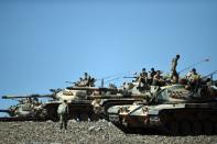 Turkish tanks line up on a hill near the border with Syria in 2014