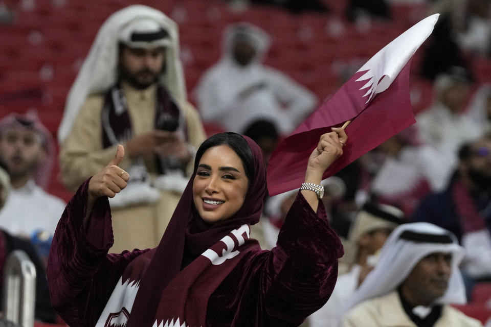 A Qatar fan cheers for her team before the quarterfinal soccer match between Qatar and Uzbekistan at Al Bayt stadium in Al Khor, Qatar, Saturday, Feb. 3, 2024. (AP Photo/Thanassis Stavrakis)