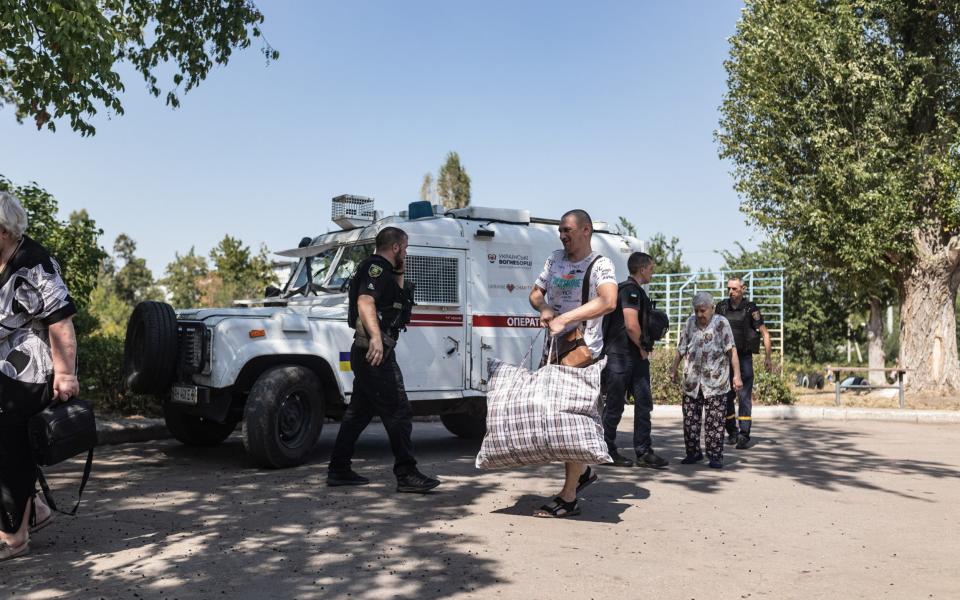 Ukrainian emergency service workers and police evacuate civilians from the village of Ukrainsk, close to the front line in Pokrovsk