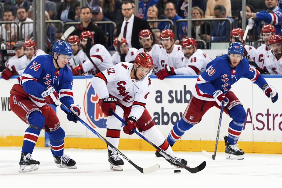 New York Rangers right wing Kaapo Kakko (24), left wing Will Cuylle (50) and Carolina Hurricanes center Jesperi Kotkaniemi (82) fight for the puck during the first period in Game 2 of an NHL hockey Stanley Cup second-round playoff series, Tuesday, May 7, 2024, in New York. (AP Photo/Julia Nikhinson)