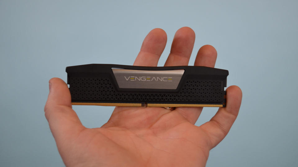 A man's hand holding Corsair Vengence DDR5 RAM