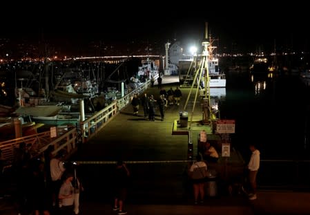 FILE PHOTO: Rescue personnel exit the city pier after unloading the victims of a pre-dawn fire that sank a commercial diving boat off the coast of Santa Barbara, California