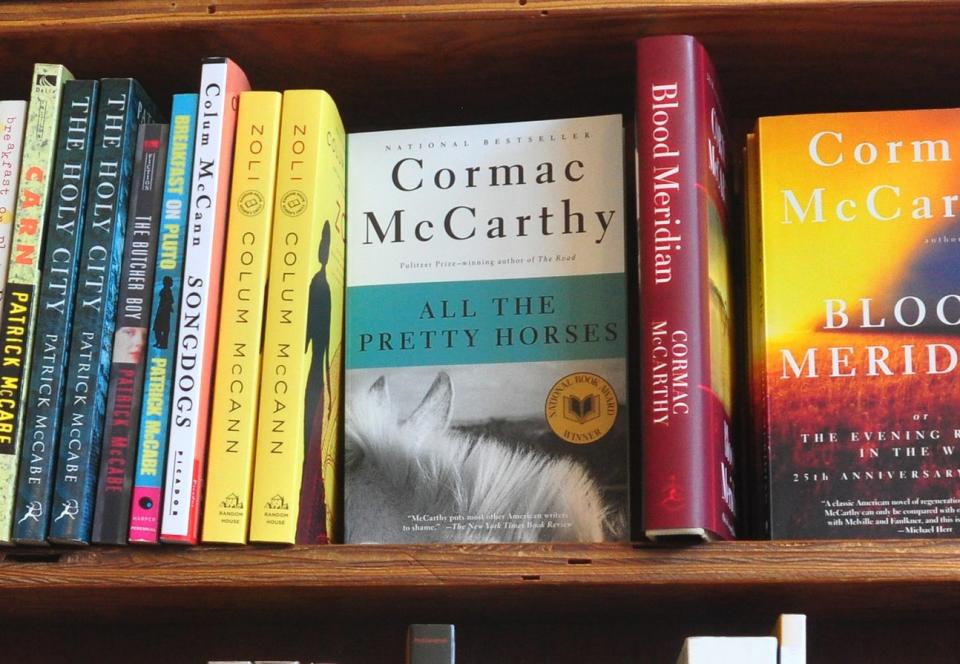 A copy of All the Pretty Horses on a shelf in a bookstore