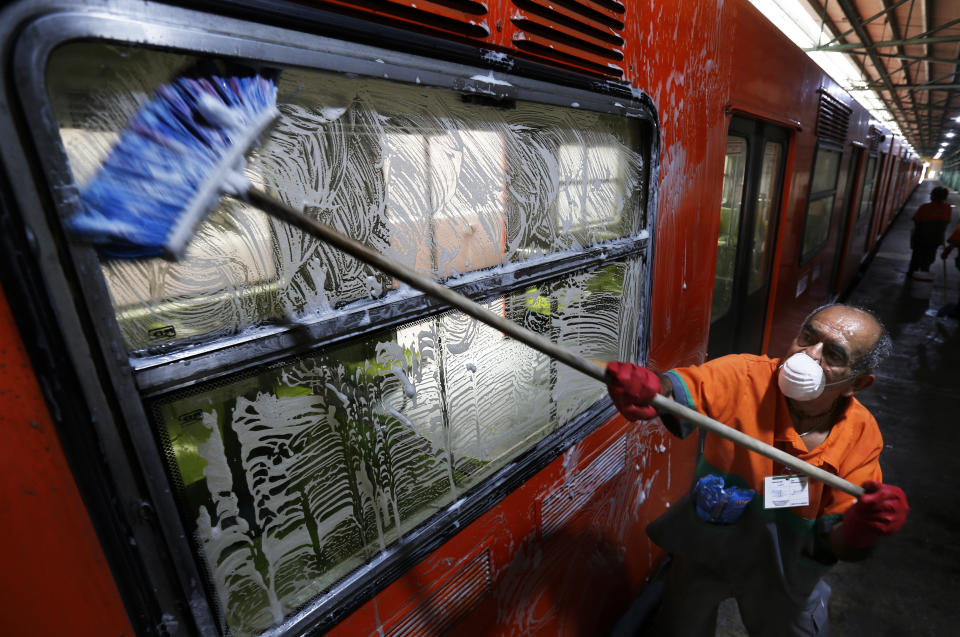 A member of cleaning crew washes metro car as a preventive measure against the spread of the new coronavirus in Mexico City, Wednesday, March 18, 2020. For most people COVID-19 causes mild or moderate symptoms. For others, especially the elderly and people with existing health problems, it can cause many other serious illnesses, including pneumonia. (AP Photo/Marco Ugarte)