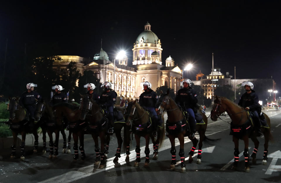 Serbian police guards the area in front of the parliament building after clashing with protesters in Belgrade, Serbia, Wednesday, July 8, 2020. Police have fired tear gas at protesters in Serbia's capital during the second day of demonstrations against the president's handling of the country's coronavirus outbreak. President Aleksandar Vucic backtracked on his plans to reinstate a coronavirus lockdown in Belgrade this week, but it didn't stop people from firing flares and throwing stones while trying to storm the downtown parliament building. (AP Photo/Darko Vojinovic)