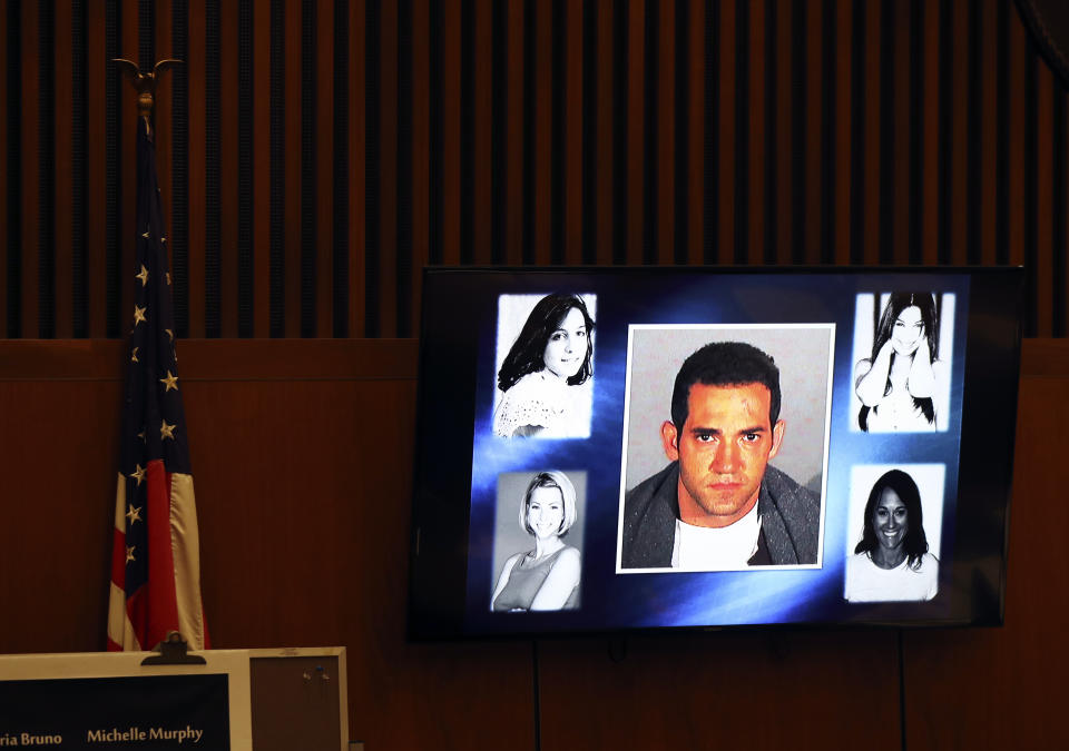 A picture of defendant Michael Gargiulo, center, and his victims is flashed on a screen during closing arguments for the trial of People vs. Michael Gargiulo Tuesday, Aug. 6, 2019, in Los Angeles. Closing arguments started Tuesday in the trial of an air conditioning repairman charged with killing two Southern California women and attempting to kill a third. (Lucy Nicholson, Pool Photo via AP)