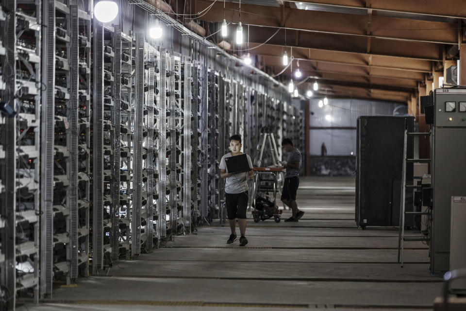 Technicians inspect bitcoin mining machines at a facility in China.