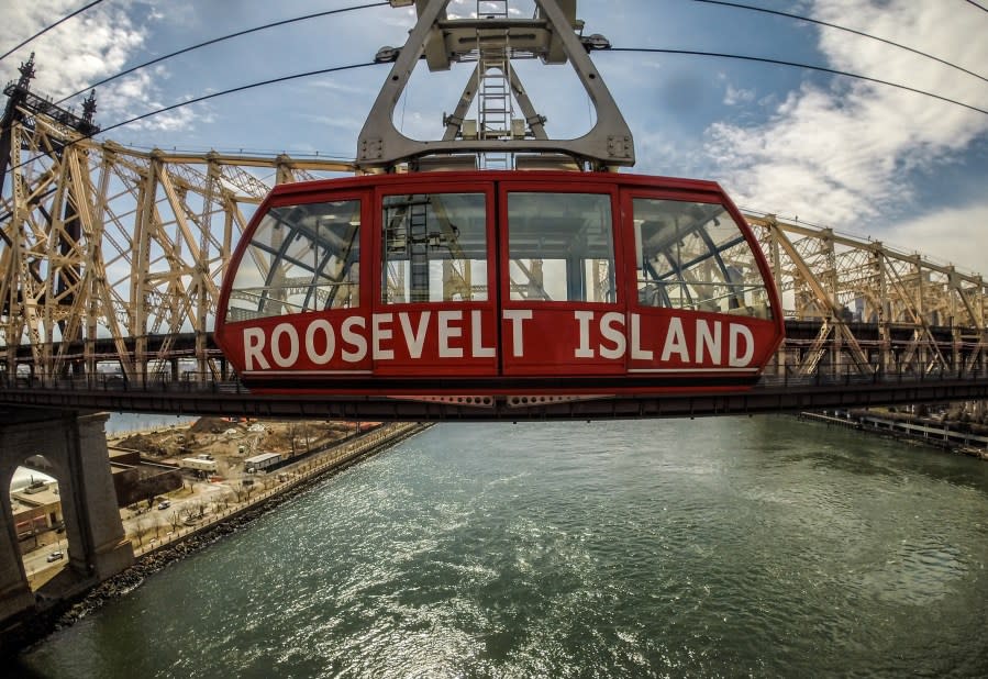 A Roosevelt Island Tram goes past the Queensboro Bridge in Manhattan, New York, USA. (Credit: Chris J Ratcliffe / Getty Images)