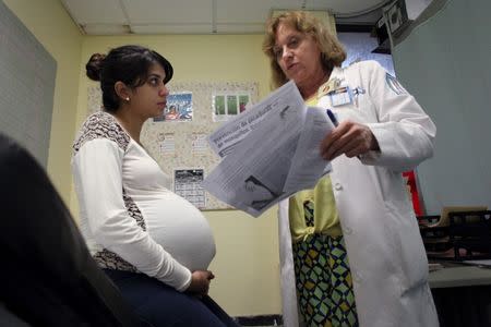 Nancy Trinidad, who is 32 weeks pregnant, listens to the explanation of a doctor about how to prevent Zika, Dengue and Chikungunya viruses at a public hospital in San Juan, Puerto Rico, February 3, 2016. REUTERS/Alvin Baez