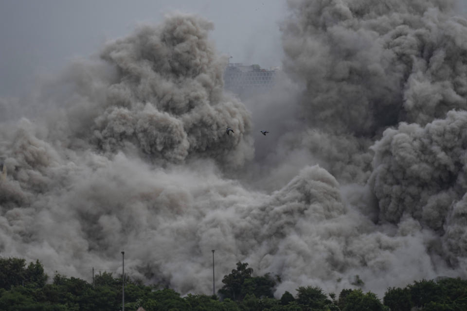 Cloud of dust rises as twin high-rise apartment towers are razed to ground in Noida, outskirts of New Delhi, India, Sunday, Aug. 28, 2022. The demolition was done after the country's top court declared them illegal for violating building norms. The 32-story and 29-story towers, constructed by a private builder were yet to be occupied and became India's tallest structures to be razed to the ground. (AP Photo/Altaf Qadri)