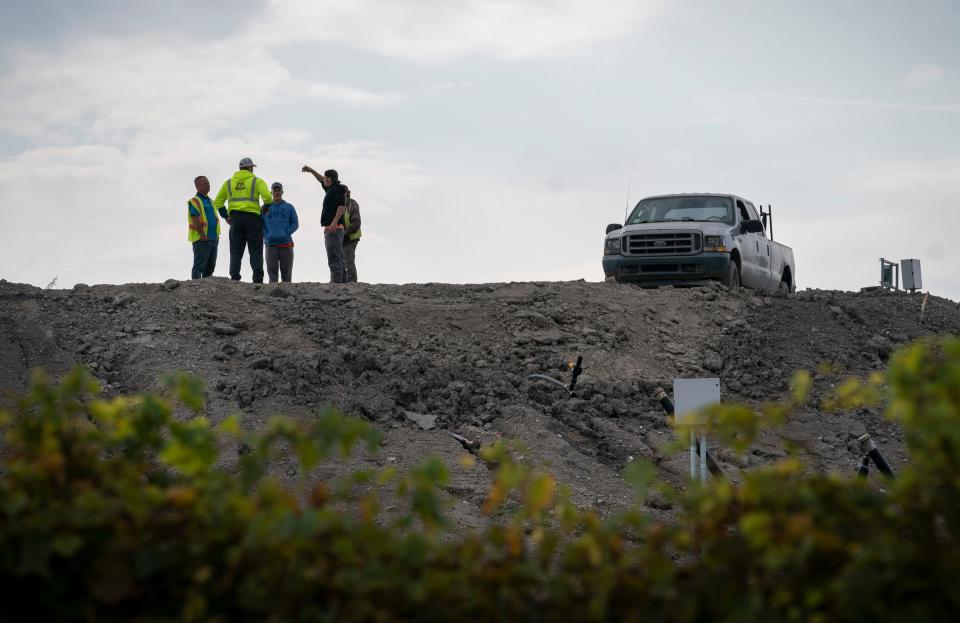 Workers gather on a ridge at the Wayne Disposal Inc. landfill in Belleville, located near the Willow Run Airport, on Wednesday, Sept. 20, 2023.
