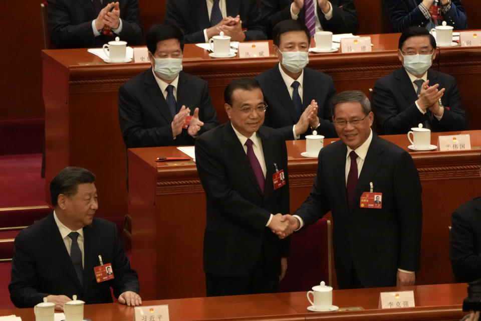 FILE - Chinese President Xi Jinping, at left, looks on as newly elected Chinese Premier Li Qiang at right shakes hands with former Premier Li Keqiang during a session of China's National People's Congress (NPC) at the Great Hall of the People in Beijing on March 11, 2023. (AP Photo/Mark Schiefelbein, File)