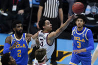 Gonzaga guard Andrew Nembhard, center, drives to the basket between UCLA forward Cody Riley, left, and guard Johnny Juzang, right, during the first half of a men's Final Four NCAA college basketball tournament semifinal game, Saturday, April 3, 2021, at Lucas Oil Stadium in Indianapolis. (AP Photo/Darron Cummings)