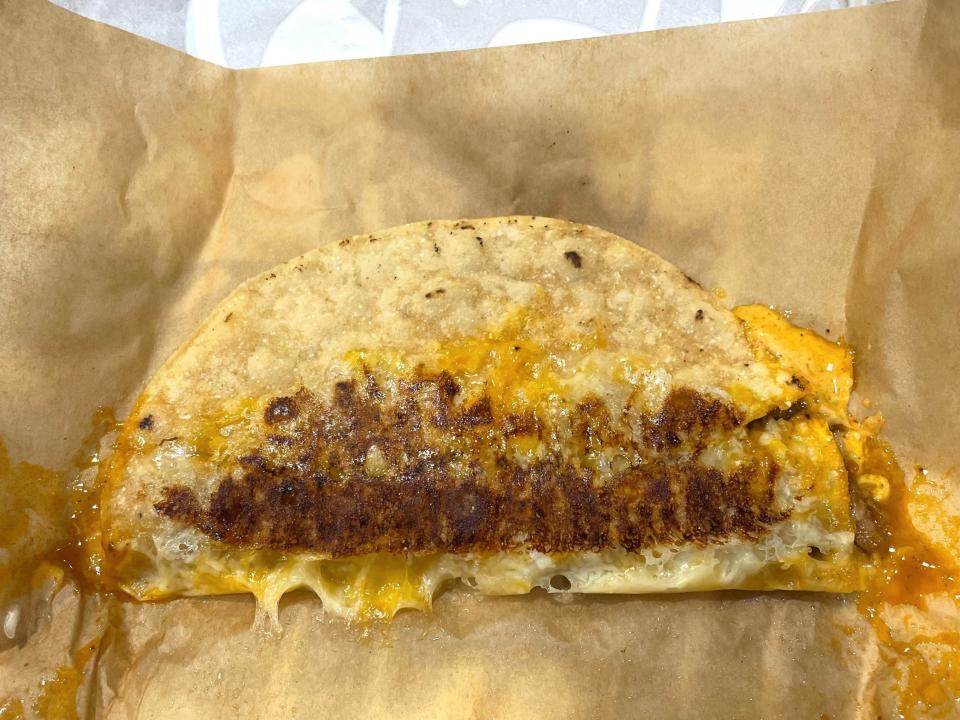 A brown piece of paper with Taco Bell's Grilled Cheese Dipping Taco in the middle
