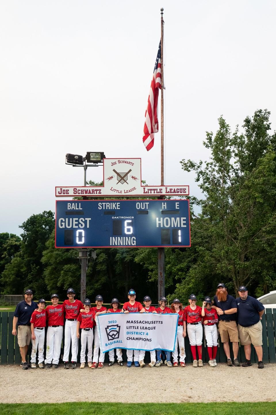 Rutland players and coaches pose with their District 4 championship banner at Joe Schwartz Field in Worcester on Wednesday July 12, 2023.