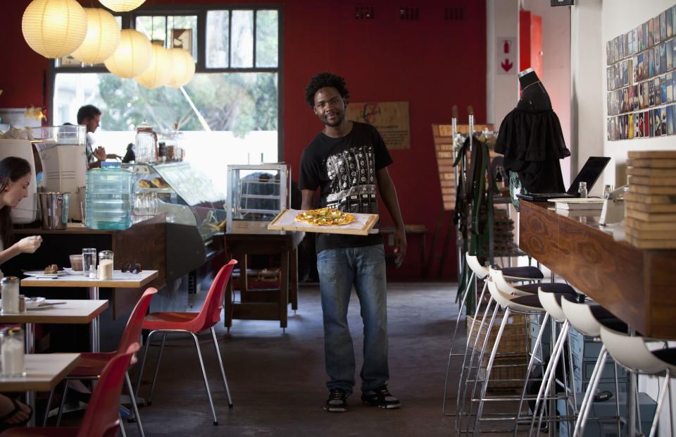 <h2>Waiting tables in Durban</h2>Terence Kamanda, a 25 year-old waiter, poses for a picture as he serves customers in The Corner Cafe restaurant in Durban, April 26, 2012. The Zimbabwean national studied for 18 months at the London Chamber of Commerce Institute College in Gweru, Zimbabwe, where he received a diploma in marketing. He hoped to find a job in marketing but has been working as a waiter for eight months.