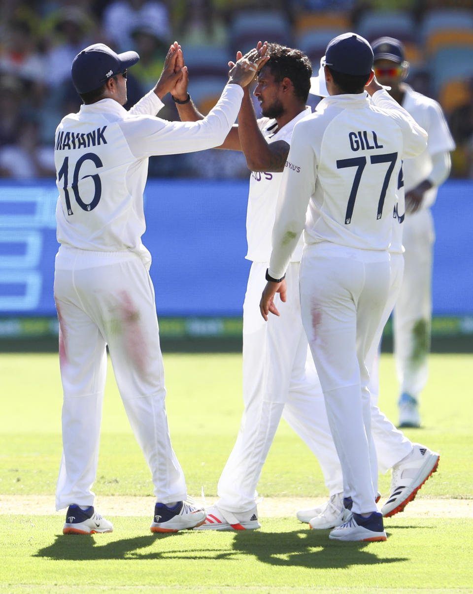 India's Thangarasu Natarajan, centre, is congratulated by teammates after dismissing of Australia's Marnus Labuschagne during play on the first day of the fourth cricket test between India and Australia at the Gabba, Brisbane, Australia, Friday, Jan. 15, 2021. (AP Photo/Tertius Pickard)