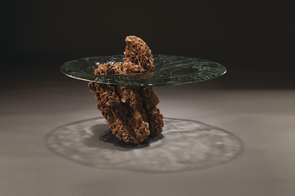 This image provided by Studio Greytak shows an outer space themed table. Studio Greytak, in Missoula, Montana, has designed the Impact table, where a chunk of desert rose crystals is embedded with cast glass, as though a piece of asteroid had plunged into a pool. (David Baumstark via AP)