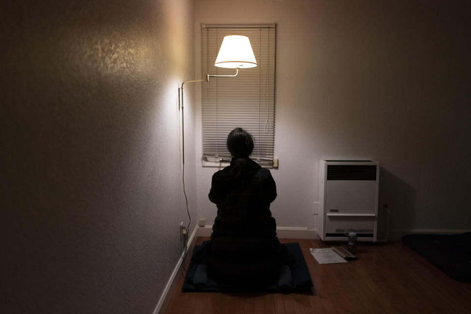 Yaso Thiru meditates facing a wall during a Sunday practice at the Anchorage Zen Community in Anchorage, Alaska, Sunday, Oct. 9, 2022. Thiru grew up in a Hindu household in Sri Lanka, a majority Buddhist country. She became interested in Buddhism and joined the Anchorage group after the outbreak of the coronavirus pandemic. (AP Photo/Jae C. Hong)