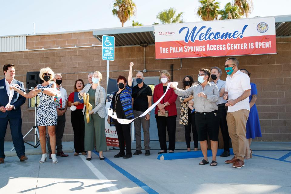 Linda Barrack, CEO of Martha's Village and Kitchen, center, celebrates by raising her arm after the ribbon cutting ceremony for the Palm Springs Access Center in Palm Springs, Calif., on September 30, 2021. Palm Springs Access Center is a daytime drop-in facility offering wraparound services for individuals experiencing homelessness. 