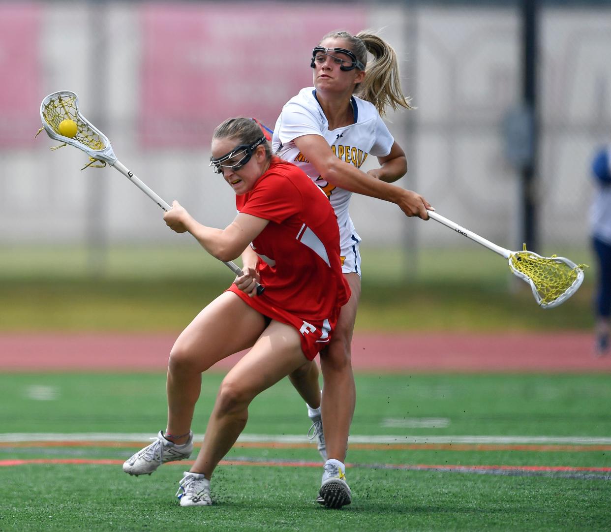Fairport's Ella Peers, left, avoids pressure from Massapequa's Joely Caramelli during the NYSPHSAA Girls Lacrosse Championships Class A final in Cortland, N.Y., Saturday, June 10, 2023.  Fairport won the Class A title with an 10-9 double overtime win over Massapequa.
