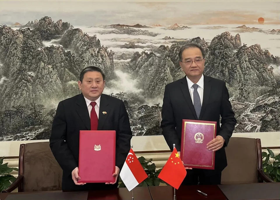 Peter Tan (left), Singapores Ambassador to the Peoples Republic of China, holding the mutual 30-day visa exemption agreement with a Chinese official. (PHOTO: Facebook/Singapore Embassy in China)