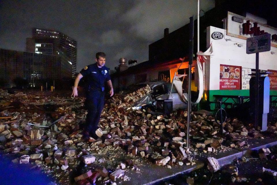 New Orleans Police detective Alexander Reiter, looks over debris from a building that collapsed during Hurricane Ida in New Orleans, Monday, Aug. 30, 2021.