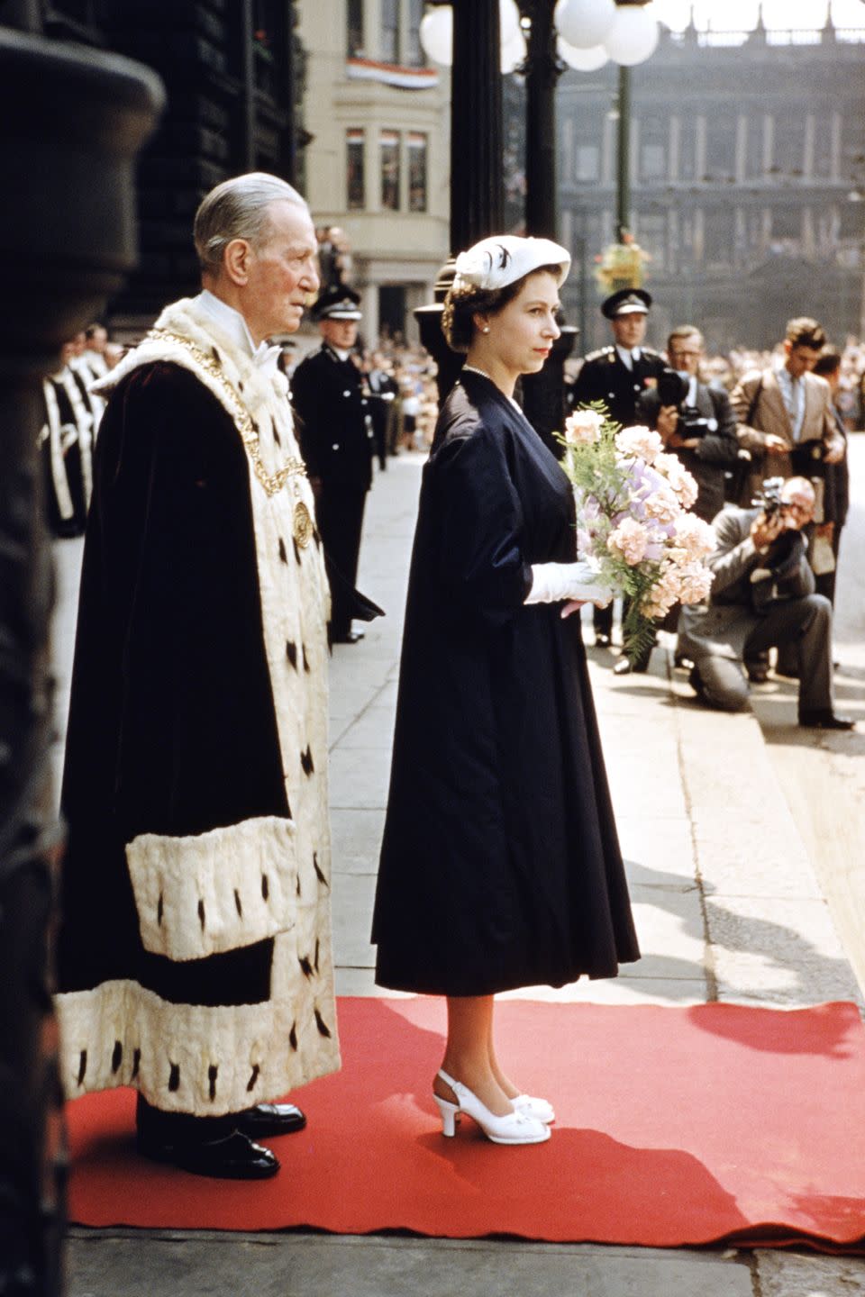 <p>In a blue A-line dress with white heels and gloves outside the City Chambers in Glasgow during a Coronation Tour of Scotland. Next to her is the Lord Provost of Glasgow, Thomas Kerr.</p>