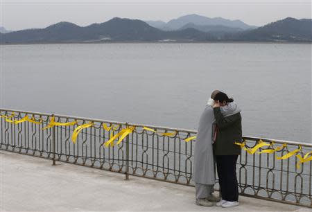 A Buddhist nun comforts the crying family member of a missing passenger onboard the capsized Sewol ferry at a port in Jindo April 26, 2014. REUTERS/Kim Kyung-Hoon