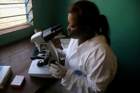 FILE PHOTO: A laboratory worker uses a microscope at the health centre in the commune of Wangata during a vaccination campaign against the outbreak of Ebola, in Mbandaka, Democratic Republic of Congo, May 23, 2018. REUTERS/Kenny Katombe/File Photo