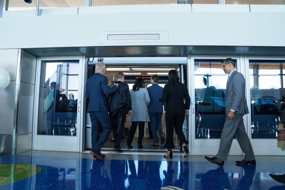 People board the PHX Sky Train at the 24th Street Station for its first trip to the rental car center during media day at Phoenix Sky Harbor International Airport on Dec. 19, 2022, in Phoenix, Ariz. Stage 2 of the PHX Sky Train extends the train's route to the Rental Car Center and begins transporting airport travelers on Dec. 20, 2022.