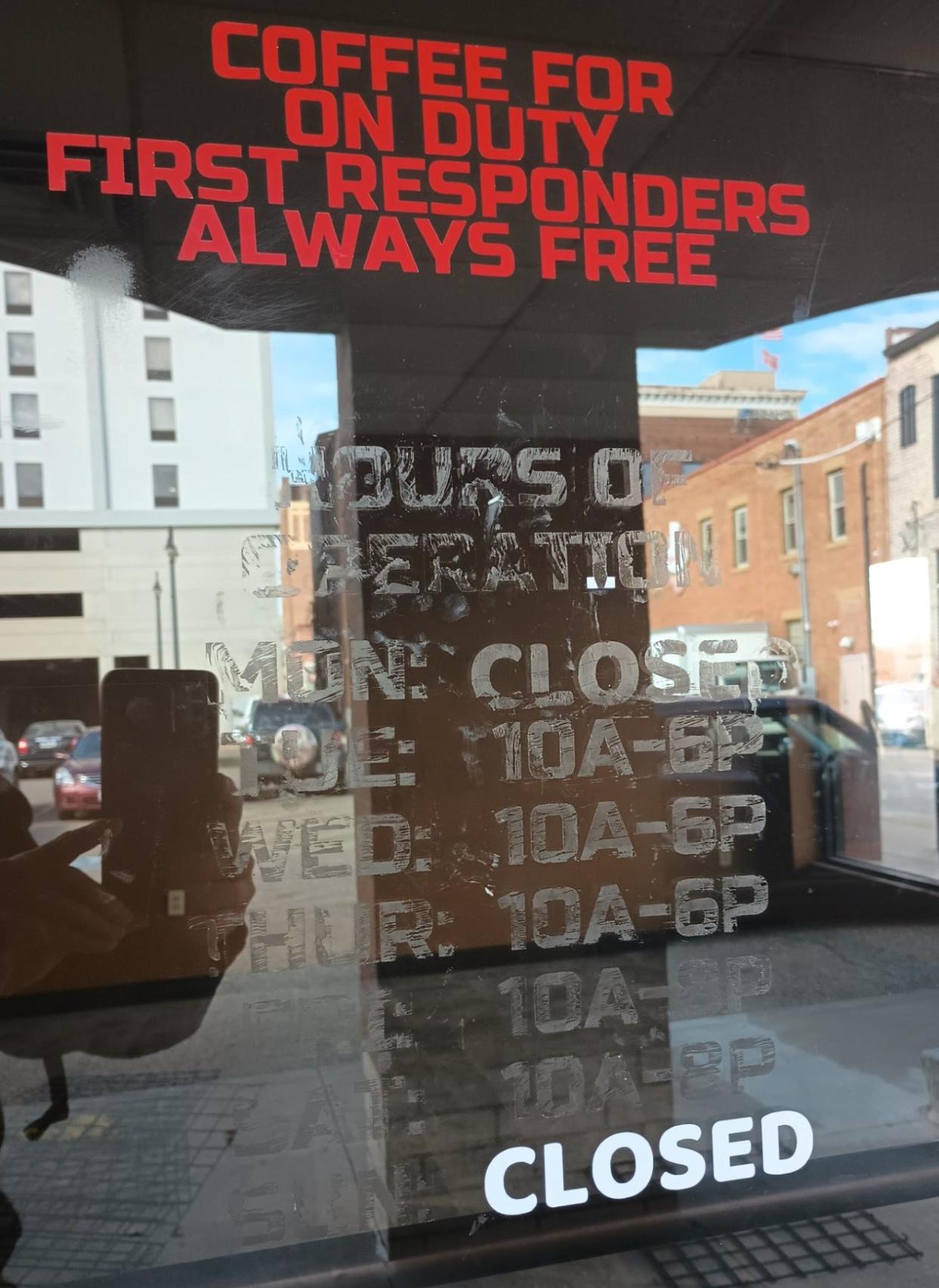 Information detailing the days and hours of operation for Caffeine & Gunpowder has been scratched off an outside window of the downtown Massillon business. The only legible marking says "closed."