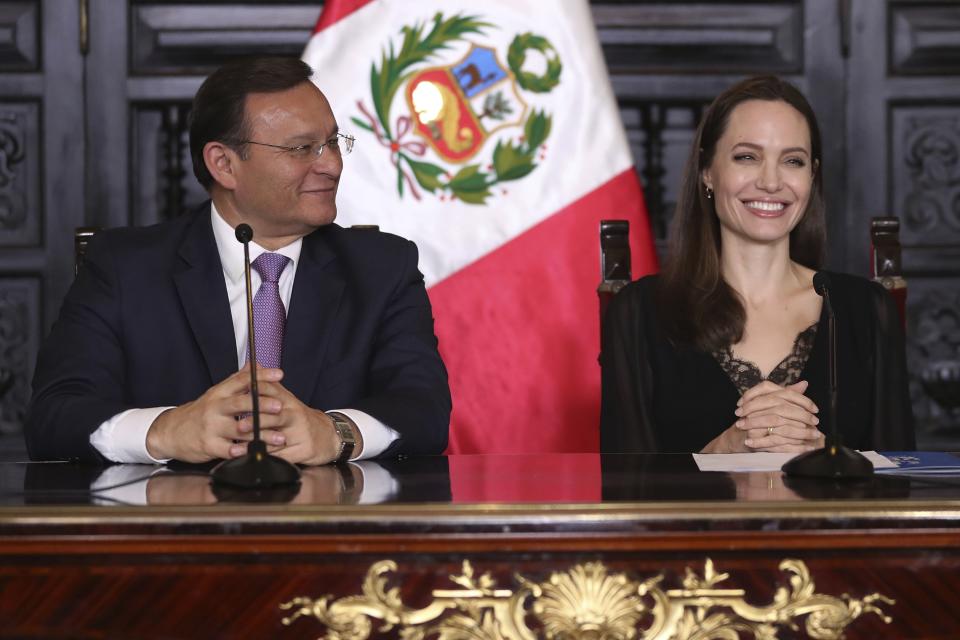 Hollywood actress Angelina Jolie and Peru's Foreign Minister Nestor Popolizio hold a joint press conference at government palace in Lima, Peru, Tuesday, Oct. 23, 2018. Jolie, who met with Venezuelans refugees on Monday, is in Peru as a special envoy for the UN's High Commissioner for Refugees. (AP Photo/Martin Mejia)