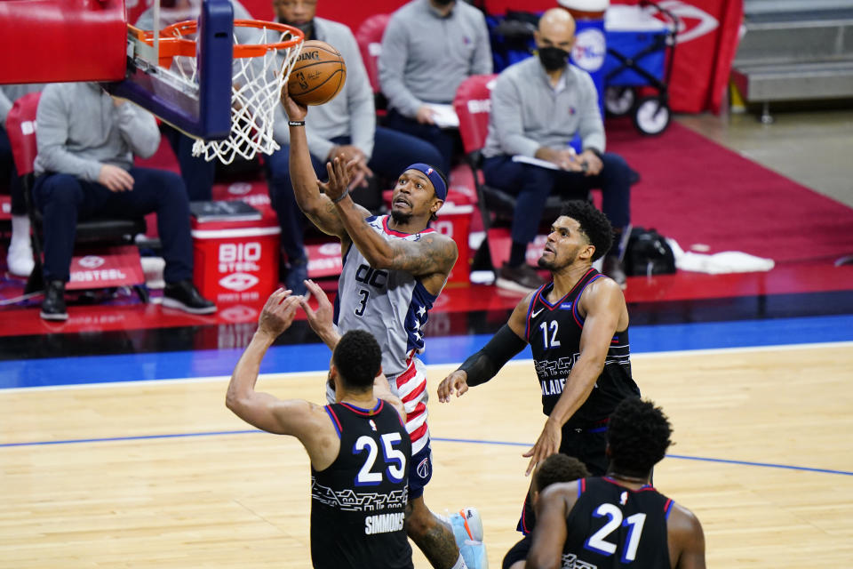 Washington Wizards' Bradley Beal (3) goes up for a shot against Philadelphia 76ers' Ben Simmons (25) and Tobias Harris (12) during the second half of Game 2 in a first-round NBA basketball playoff series, Wednesday, May 26, 2021, in Philadelphia. (AP Photo/Matt Slocum)