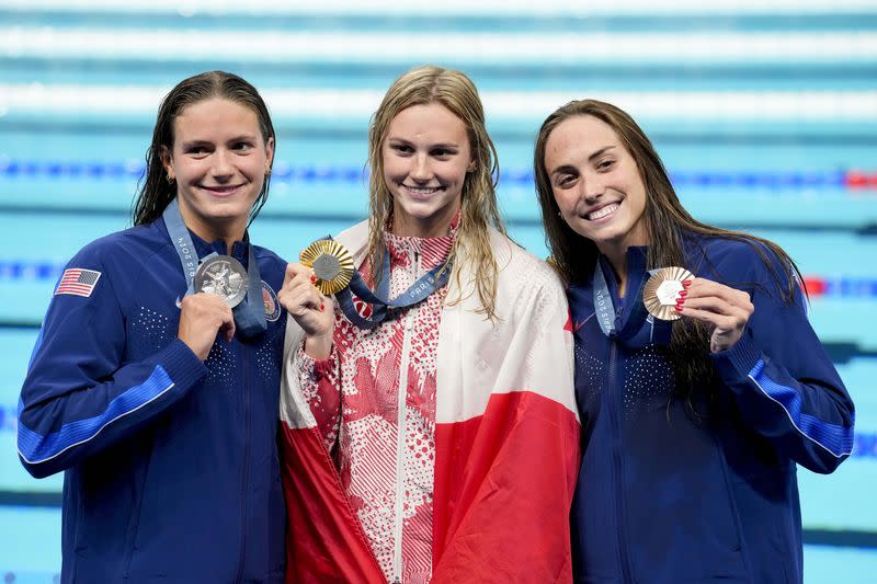 Katie Grimes (EE.UU.), Summer McIntosh (Canadá) y Emma Weyant (EE.UU.) en la ceremonia de entrega de medallas de los 400m combinado individuales femeninos en los Juegos Olímpicos de París 2024, en la piscina de la Defense Arena, Nanterre, Francia