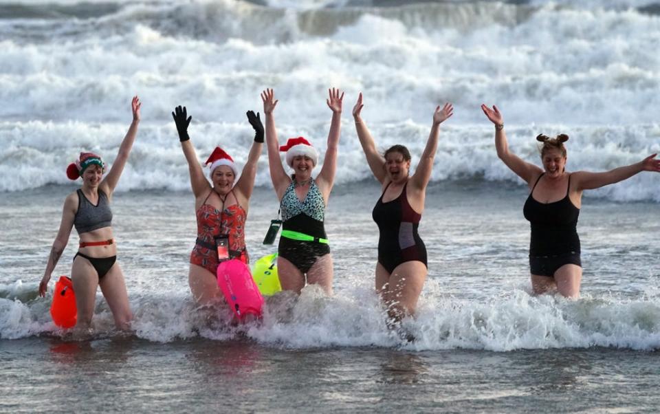 The swimmers cheer after the bracing Christmas Day dip at Tynemouth Beach (Owen Humphreys/PA) (PA Wire)