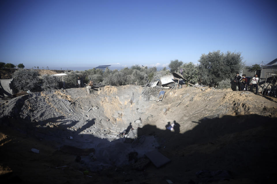 Palestinians inspect a big crater caused by Israeli airstrikes on Khan Younis, Gaza Strip, Thursday, Jan. 4, 2024. (AP Photo/Mohammed Dahman)