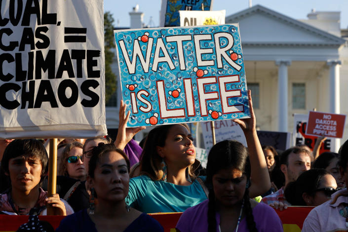 <p>Nikki Bass, center, holds up a sign that says “Water is life” as she rallies in front of the White House with members of the Standing Rock Sioux Tribe and others who oppose the Dakota Access oil pipeline, on Sept. 13, 2016, in Washington, D.C. (Photo: Jacquelyn Martin/AP) </p>