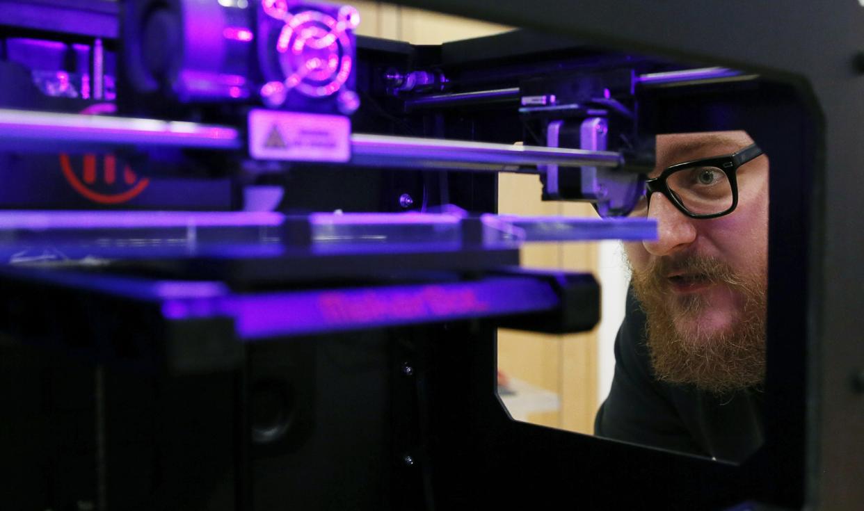 TechShop representative Andy Leer calibrates a MakerBot Replicator 2 desktop 3D printer. REUTERS/Gary Cameron