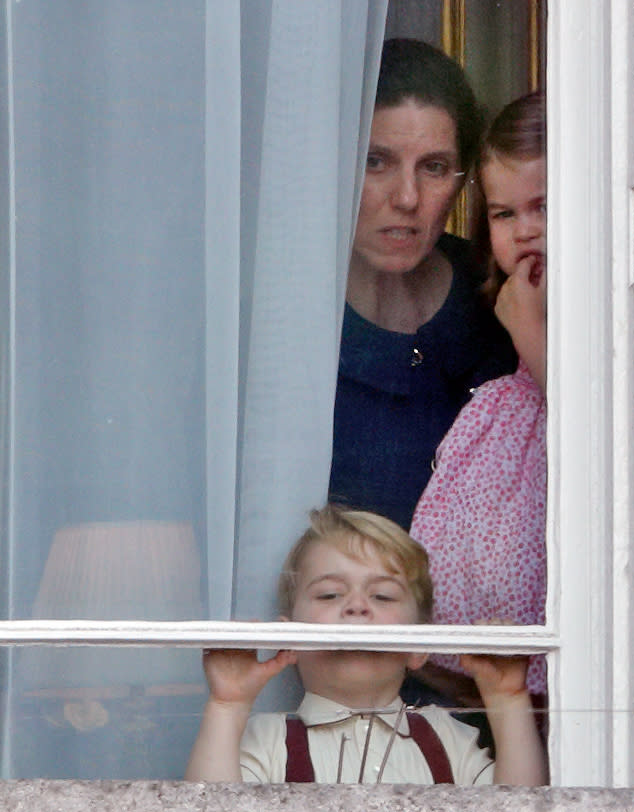 Prince George, Princess Charlotte and Maria Teresa Borrallo peer out of a window at Buckingham Palace during Trooping the Colour 2017