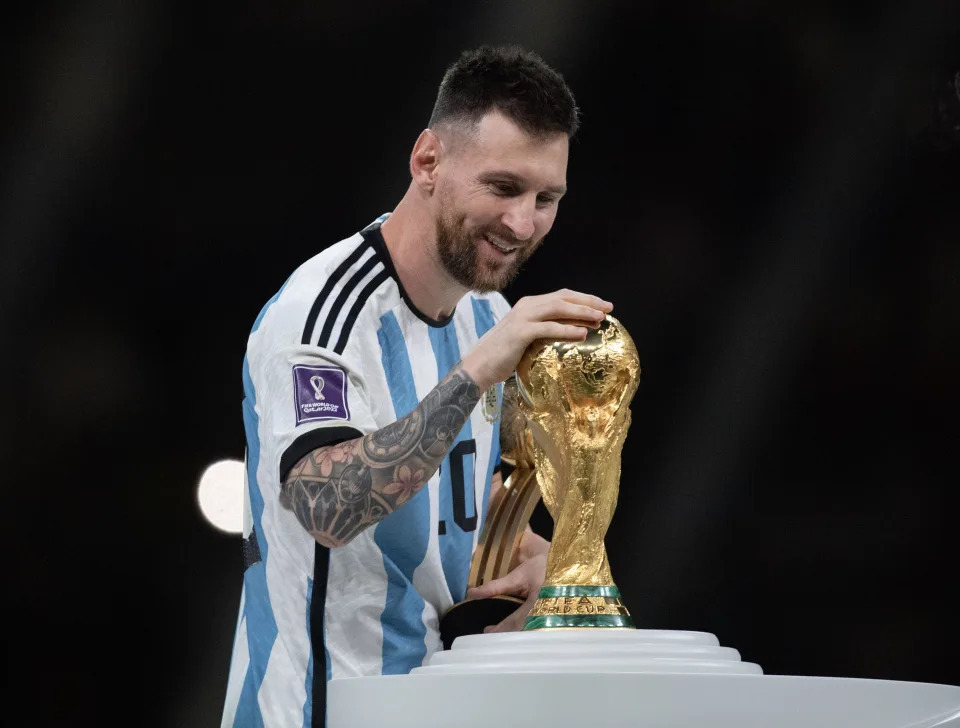 Argentina star Lionel Messi touches the World Cup trophy during the prize presentation ceremony at the 2022 World Cup. 