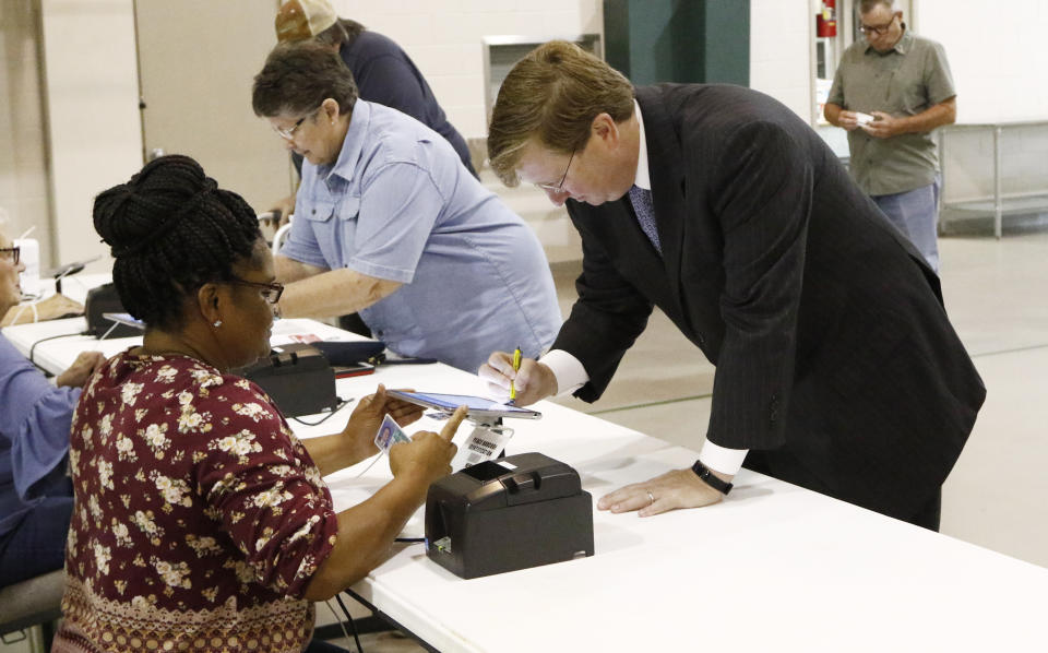 Lt. Gov. Tate Reeves signs his name onto the electronic voting log as poll worker Shirley Trigg checks his voter id in his Flowood, Miss., precinct, Tuesday, Aug. 27, 2019. Reeves is in a runoff for the Republican Party nomination for governor against former Mississippi Supreme Court Chief Justice Bill Waller Jr. (AP Photo/Rogelio V. Solis)