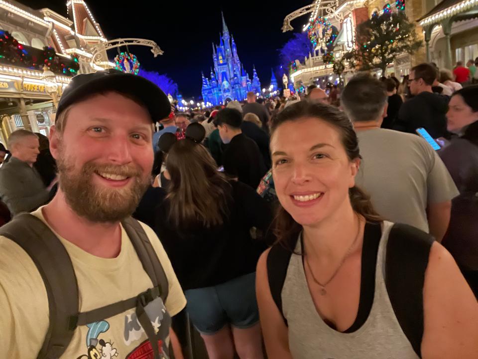 tim and a friend posing for a photo on main street USA in magic kingdom at night