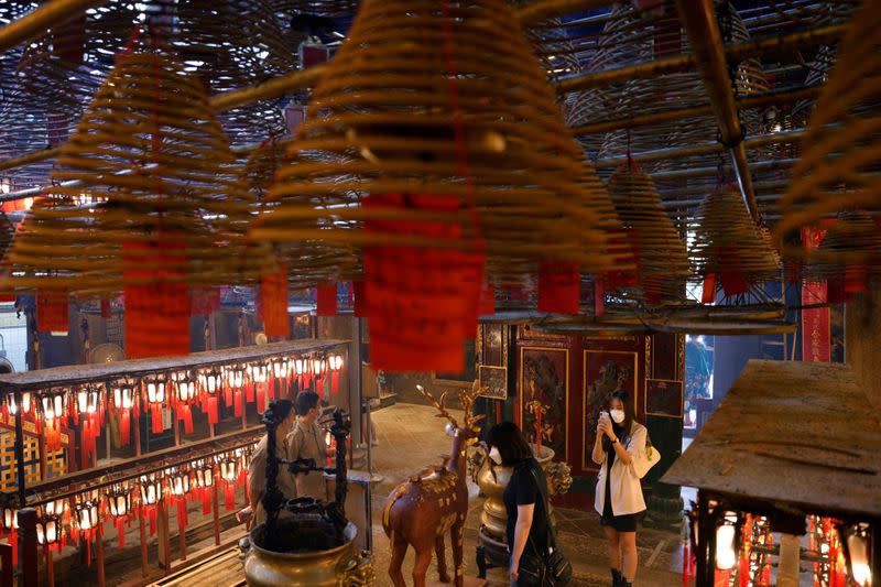 FILE PHOTO: Visitors wearing face masks visit Man Mo Temple for a Hong Kong Tourism Board's free local tour, following the coronavirus disease (COVID-19) outbreak, in Hong Kong