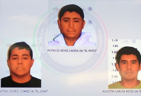 Pictures of the detainees for the case of missing students of Ayotzinapa are seen displayed on a television screen during a news conference at the Attorney General's Office building in Mexico City in this November 7, 2014, handout courtesy of the office. REUTERS/Attorney General's Office/Handout via Reuters