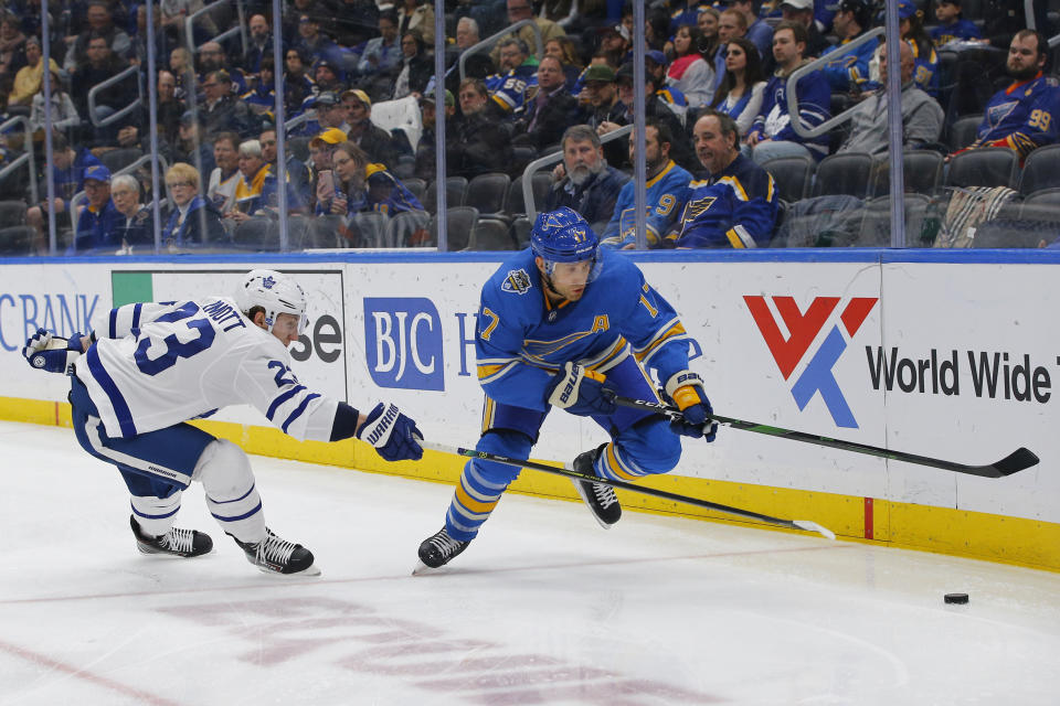 St. Louis Blues' Jaden Schwartz, right, reaches for a loose puck as he is pressured by Toronto Maple Leafs' Travis Dermott during the second period of an NHL hockey game Saturday, Dec. 7, 2019, in St. Louis. (AP Photo/Billy Hurst)